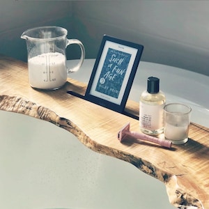Peut inclure: Un plateau de bain en bois avec un livre, une bouteille d'huile à raser, une bougie et un rasoir. Le livre est intitulé "Such a Fun Age" de Kiley Reid.