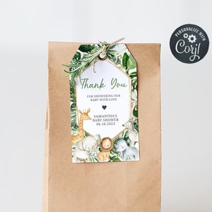 May include: A brown paper bag with a thank you tag attached. The tag has a green leafy border with a gold geometric frame. The text on the tag reads "Thank You for showering our baby with love" and "Samantha's Baby Shower 06.10.2023". There are illustrations of jungle animals on the tag.