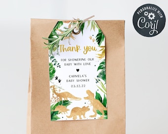 May include: A brown paper gift bag with a white tag attached. The tag has a gold and green dinosaur theme with the text "Thank you for showering our baby with love Carmela's Baby Shower 03.12.22".