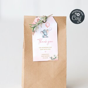 May include: A brown paper gift bag with a pink and gray elephant baby shower thank you tag. The tag features a cute elephant holding balloons and floral accents. The text on the tag reads "Thank you for showering our baby with love."