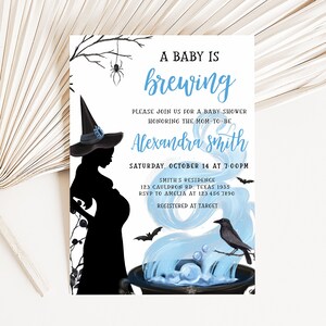 Puede incluir: Invitaci&oacute;n a baby shower con tem&aacute;tica de brujas. La invitaci&oacute;n presenta una silueta de una mujer embarazada con un sombrero de bruja, con el texto "A Baby is Brewing" en azul. Incluye detalles del evento e informaci&oacute;n de RSVP.