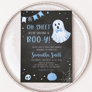 May include: A baby shower invitation with a black chalkboard background. The invitation features blue accents, including a ghost illustration, bunting, and text that reads "Oh Sheet We're Having a Boo-y!" and event details.