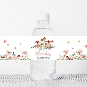 May include: Water bottle label with a floral design featuring mushrooms, flowers, and greenery. The label says "Alexandra's Baby Shower".