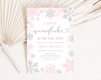 Könnte beinhalten: Eine Babyparty-Einladung mit einem rosa-silbernen Schneeflocken-Design. Der Text lautet "A Little Snowflake Is On The Way!" mit Details für die Babyparty von Ashley & David Brown, einschließlich Datum, Uhrzeit und Ort.