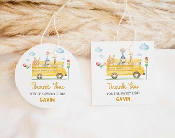 Puede incluir: Dos etiquetas blancas con una ilustración de acuarela de un autobús escolar amarillo con animales. Las etiquetas dicen "Thank You for the Sweet Ride!" y "GAVIN". Una etiqueta es redonda, la otra cuadrada.