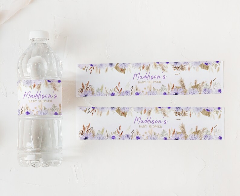 May include: Two water bottle labels with a floral design in shades of purple, brown, and white. The text on the labels reads "Maddison's Baby Shower".