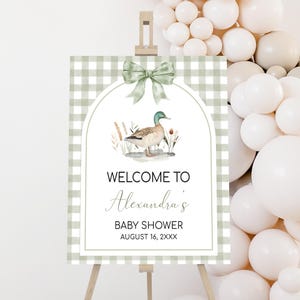a welcome sign for a baby shower with balloons in the background