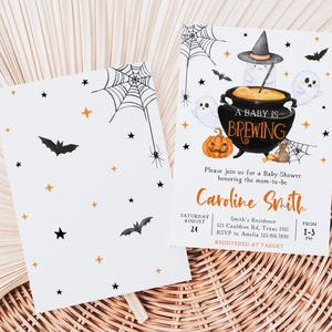 K&ouml;nnte beinhalten: Halloween-Babyparty-Einladungen. Das Design zeigt einen Kessel mit dem Text "A Baby is Brewing", Geister, Flederm&auml;use und einen K&uuml;rbis. Die Einladung enth&auml;lt den Namen "Caroline Smith" und Veranstaltungsdetails.
