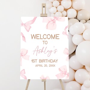 a welcome sign surrounded by white balloons