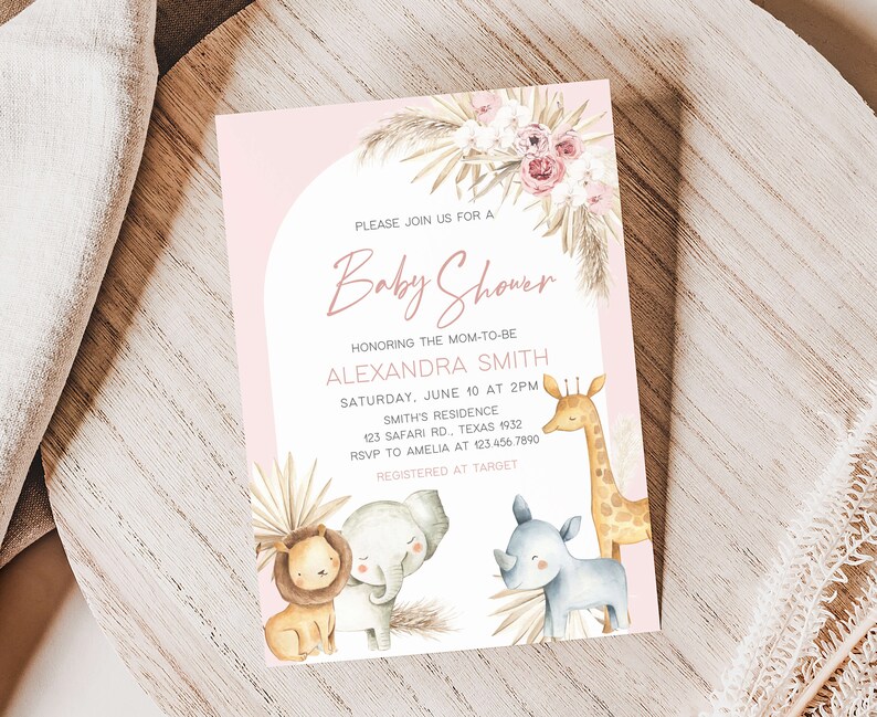 May include: A pink and white baby shower invitation with a watercolor illustration of a giraffe, rhino, lion, and elephant. The text reads "Please join us for a Baby Shower honoring the mom-to-be Alexandra Smith, Saturday, June 10 at 2pm, Smith's Residence, 123 Safari Rd, Texas 1932, RSVP to Amelia at 123.456.7890, Registered at Target."