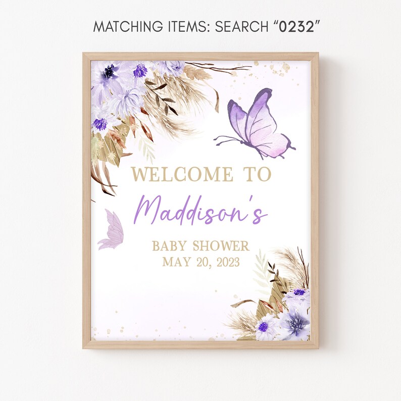 May include: A white sign with a wooden frame, featuring a purple butterfly, floral accents, and the text "WELCOME TO Maddison's BABY SHOWER MAY 20, 2023".