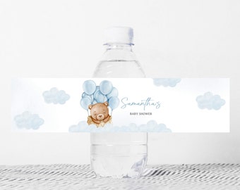 Może przedstawiać: Etykieta na butelkę wody z niebieskim i brązowym misiem trzymającym niebieskie balony. Etykieta zawiera również tekst "Baby Shower Samanthy".