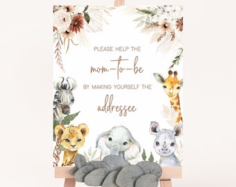 May include: A white sign with brown text that says "PLEASE HELP THE mom-to-be BY MAKING YOURSELF THE addressee". The sign is decorated with watercolour illustrations of a zebra, lion, elephant, giraffe, and rhinoceros. The sign is on a small wooden easel.