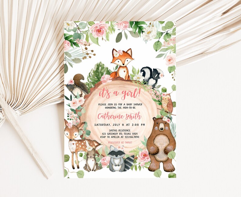 Puede incluir: &iexcl;Es una ni&ntilde;a! Invitaci&oacute;n a una fiesta de bienvenida al beb&eacute; con un borde floral rosa y verde y animales del bosque, incluyendo un zorro, una ardilla, un ciervo, un oso, un mapache y un b&uacute;ho. El texto dice "&iexcl;Es una ni&ntilde;a!" e incluye la fecha, hora y lugar de la fiesta.