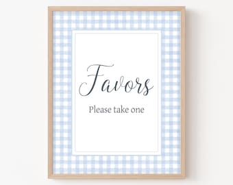 May include: A framed sign with a blue and white gingham pattern border. The sign says "Favors" in a cursive font and "Please take one" in a smaller font.
