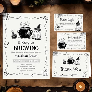 a Halloween-themed baby shower invitation and thank you cards. The invitation features illustrations of a baby, a witch, and a cauldron, along with the text "A Baby is BREWING" and "Maddison Brown". The thank you cards also have illustrations of a baby, a witch, and a cauldron, along with the text "Thank You". The background includes candles and a brown paper surface.