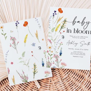 two baby in bloom cards sitting on top of a wicker basket