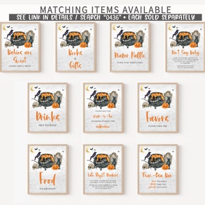 May include: A collection of framed Halloween-themed signs with watercolor illustrations. Each sign features a cauldron, skull, raven, and pumpkin. Text includes "Babies are Sweet", "Books & Gifts", and "Diaper Raffle".