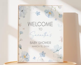 Peut inclure: Panneau de bienvenue pour une baby shower avec le texte "WELCOME TO Samantha's BABY SHOWER" en gris et bleu clair. Le panneau est orné de fleurs et de feuillages bleus de style aquarelle. La date est le 15 mars 2XXX.