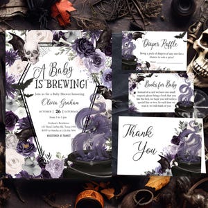 May include: A set of Halloween-themed baby shower invitations and cards. The invitation reads "A Baby is Brewing" with floral and bat illustrations in purple, white, and black. Includes a diaper raffle and thank you cards.