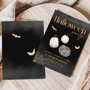 a pair of black and white pumpkins on a table