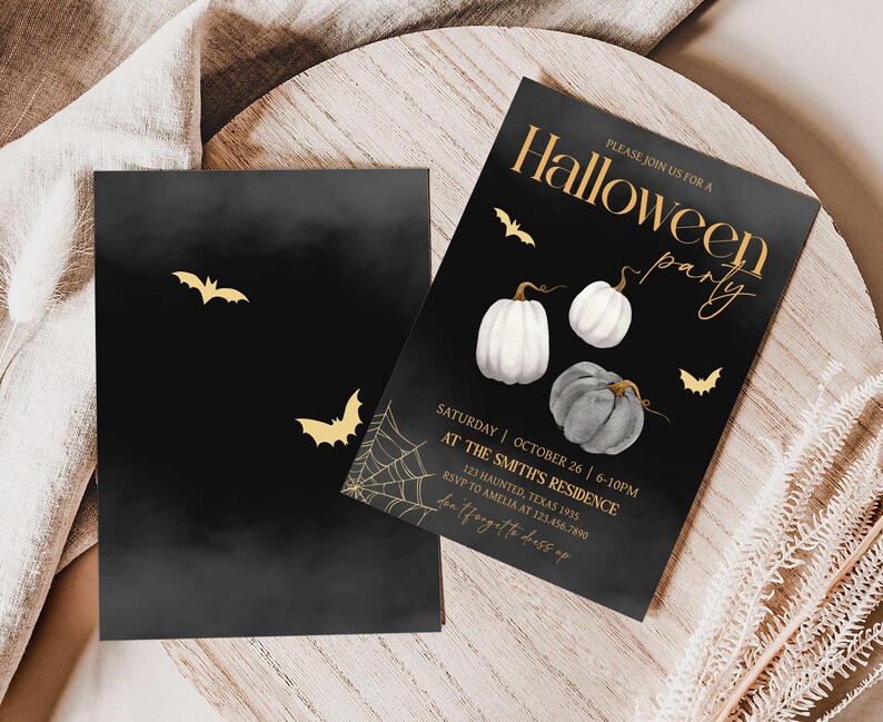 a pair of black and white pumpkins on a table
