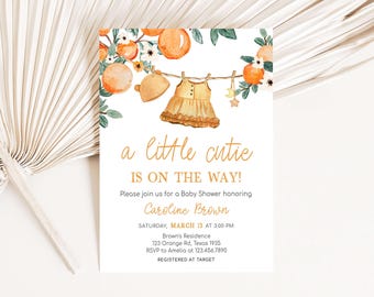 May include: A baby shower invitation featuring a watercolour illustration of a dress hanging on a clothesline with oranges and flowers. The text reads "a little cutie is on the way!" and includes details for the shower, including the date, time, location, and RSVP information.