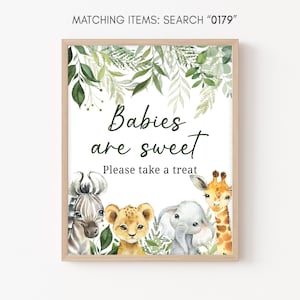 Könnte beinhalten: Ein weißes Schild mit braunem Rahmen und grünem Laub am oberen Rand. Auf dem Schild steht "Babys sind süß. Bitte nimm dir einen Leckerbissen." Auf dem Schild sind vier Tiere abgebildet: ein Zebra, ein Löwe, ein Elefant und eine Giraffe.