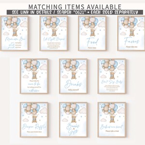 May include: Printable baby shower signs with a blue and brown colour scheme. The signs feature a cartoon bear holding balloons and text that says "Moosa Bar", "Let's Night Diapers", "Food", "Favors", "Please help the mom-to-be by making yourself the addressee", "Drinks", "Don't Say Baby", "Diaper Raffle", "Books & Gifts", and "Babies are sweet".