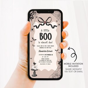 a woman holding up a phone case with a boo on it