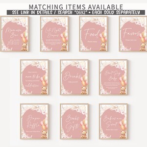May include: A set of ten framed signs with pink backgrounds and text for a baby shower. Each sign features a teddy bear, balloons, and floral accents. Text includes "Momosa Bar", "Food", and "Favors".