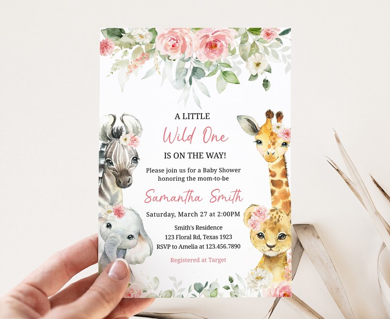 May include: A baby shower invitation with a pink floral design and illustrations of a zebra, elephant, giraffe, and lion. The text reads "A Little Wild One Is On The Way!" and includes the name "Samantha Smith", the date and time of the shower, the location, and RSVP information.