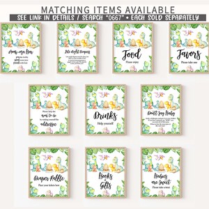 Puede incluir: Nueve carteles imprimibles con tem&aacute;tica de dinosaurios para un baby shower. Los carteles est&aacute;n decorados con hojas verdes y presentan una ilustraci&oacute;n de acuarela de una familia de dinosaurios. Los carteles incluyen t&iacute;tulos como "Bar de Mom-oza", "Pa&ntilde;ales de noche", "Comida", "Favores", "Bebidas", "No digas beb&eacute;", "Rifa de pa&ntilde;ales", "Libros y regalos" y "Los beb&eacute;s son dulces".