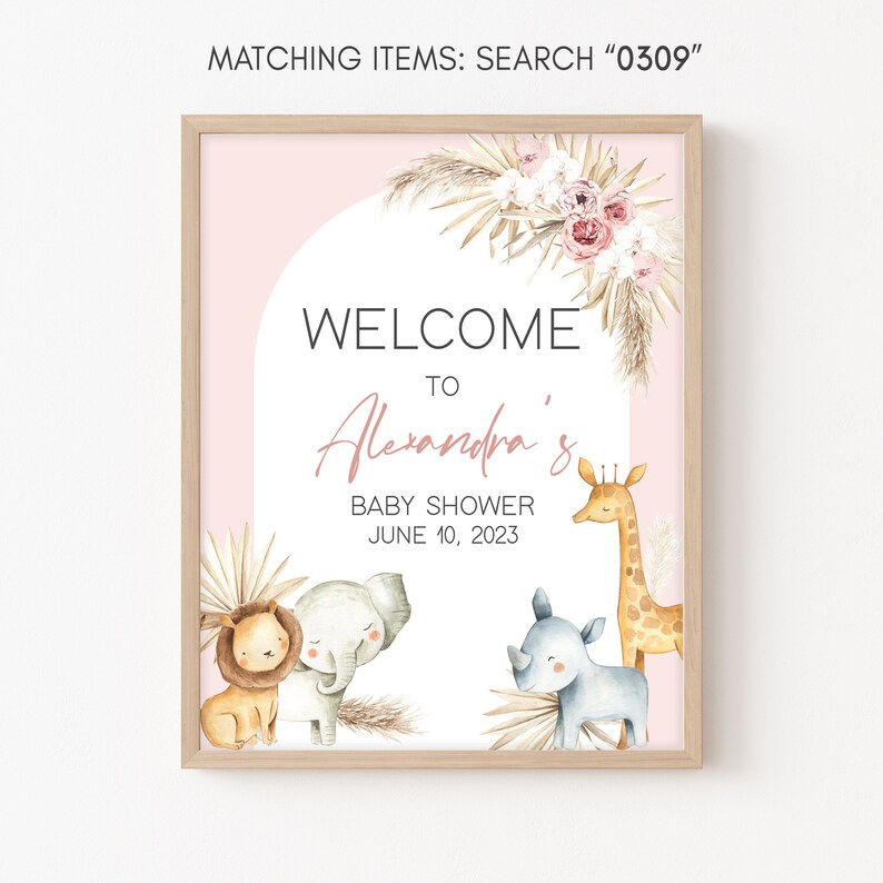 May include: A pink and white welcome sign with a brown wood frame. The sign says "Welcome to Alexandra's Baby Shower June 10, 2023". There are illustrations of a lion, elephant, rhinoceros, and giraffe.