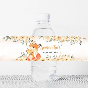 May include: Water bottle label featuring a watercolour illustration of a fox family with a floral border. The text on the label reads "Samantha's Baby Shower".