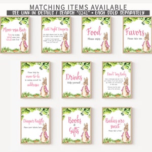 May include: Nine printable signs featuring a watercolor illustration of a rabbit wearing a pink cape. The signs are for a baby shower and include titles like "Mom-osa Bar", "Late Night Diapers", "Food", "Favors", "Drinks", "Don't Say Baby", "Diaper Raffle", "Books & Gifts", and "Babies are Sweet".