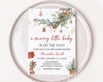 May include: A festive baby shower invitation with a Christmas theme. The invitation features the text "a merry little baby is on the way!" in red script. The design includes watercolor illustrations of Christmas ornaments, a gift, and a Christmas tree.