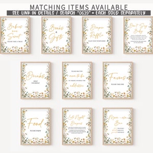 May include: A set of printable signs for a baby shower with a floral theme. The signs feature gold text on a white background with a floral border. The signs include "Babies are Sweet", "Books & Gifts", "Diaper Raffle", "Don't Say Baby", "Drinks", "Please Help the Mom-to-be by Making Yourself the Address", "Favors", "Food", "Late Night Diapers", and "Mom-osa Bar".