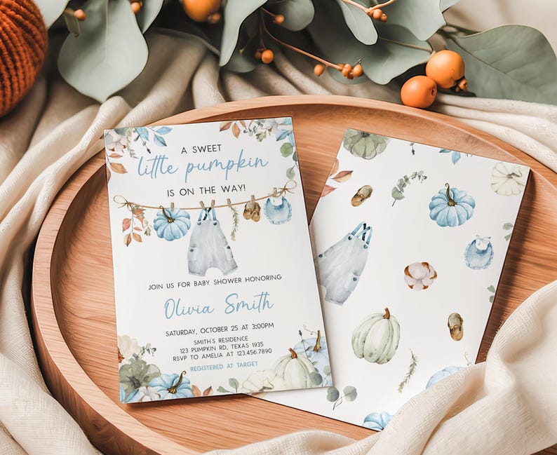 A baby shower invitation featuring a pumpkin theme, with illustrations of pumpkins, leaves, and a baby on a clothesline.