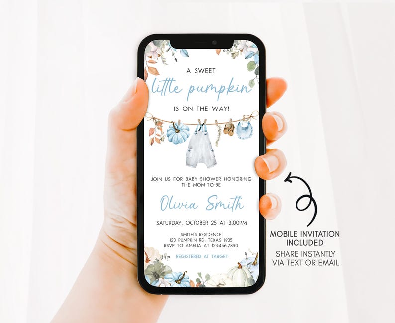 A hand holding a smartphone displaying a baby shower invitation with a floral design.