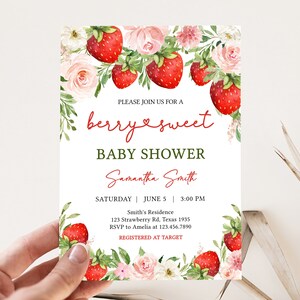 a hand holding a baby shower card with flowers and strawberries