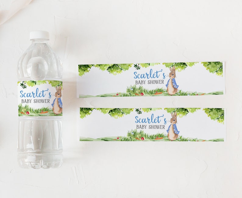 May include: Water bottle labels featuring a watercolor illustration of a rabbit wearing a blue jacket. The labels say "Scarlet's Baby Shower" in blue text.