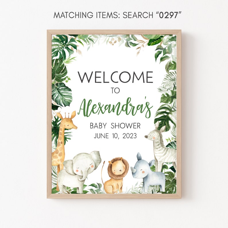 May include: A welcome sign for a baby shower with a jungle theme. The sign features a giraffe, elephant, lion, and rhinoceros, along with green leaves and the text "Welcome to Alexandras Baby Shower June 10, 2023".