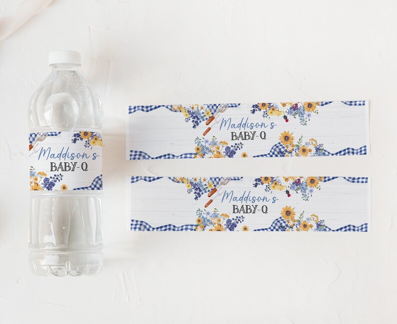 Puede incluir: Dos etiquetas con estampado de cuadros azules y blancos con un dise&ntilde;o floral y el texto "Maddison's Baby-Q" impreso en ellas. Las etiquetas est&aacute;n dise&ntilde;adas para botellas de agua.