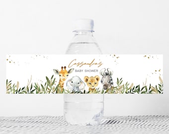May include: Water bottle label with a jungle theme. The label features a giraffe, elephant, lion, and zebra with green leaves and gold glitter. The text on the label reads "Cassandra's Baby Shower".