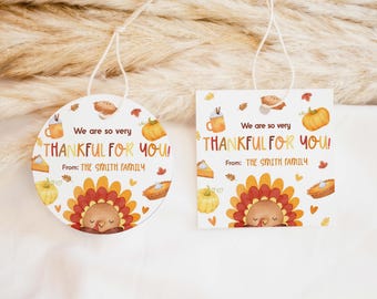 Peut inclure: Étiquettes cadeaux sur le thème de l'Action de grâce, une ronde et une carrée, avec un motif de dinde et le texte "We are so very THANKFUL FOR YOU!" et "From: THE SMITH FAMILY". Les étiquettes présentent des citrouilles, des tartes et des feuilles d'automne.