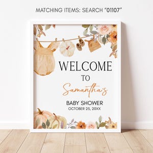 a baby shower sign hanging on a clothes line
