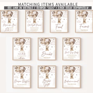 May include: A collection of framed signs with a teddy bear theme. Each sign features a teddy bear in a hot air balloon design with text such as "Momosa Bar", "Food", and "Favors". The signs are in neutral colors.