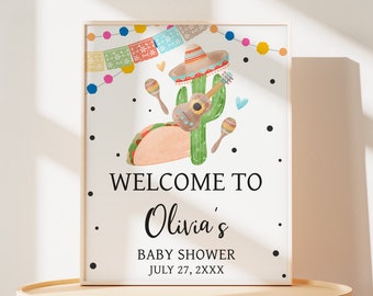 May include: A white welcome sign with black text that reads "Welcome to Olivia's Baby Shower July 27, 2XXX". The sign is decorated with a cartoon cactus wearing a sombrero, holding a guitar, and surrounded by maracas, hearts, and colorful bunting.