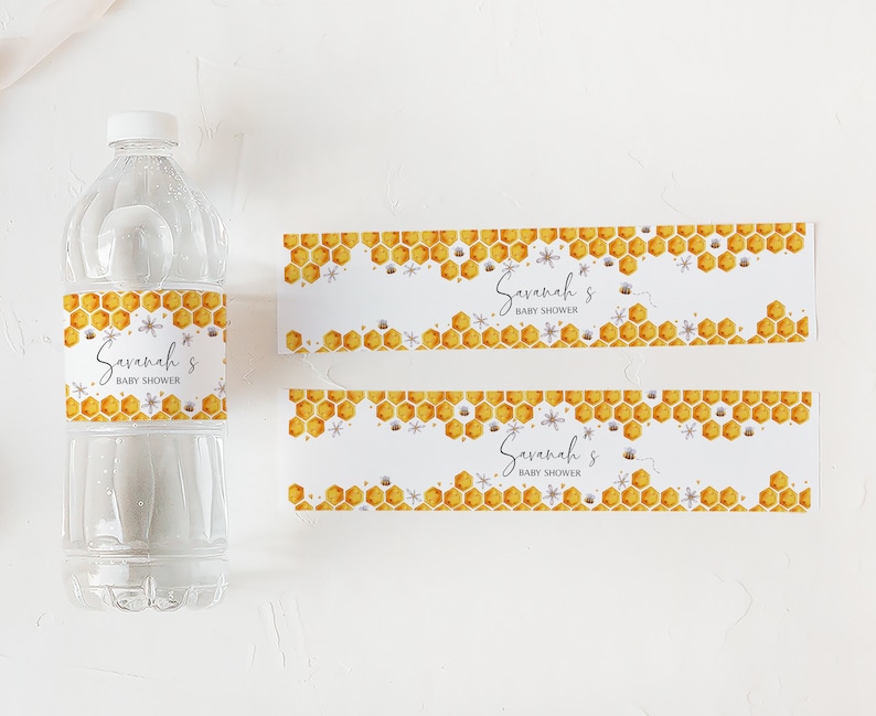 May include: Two water bottle labels with a honeycomb pattern and bees. The labels say "Savannah's Baby Shower".